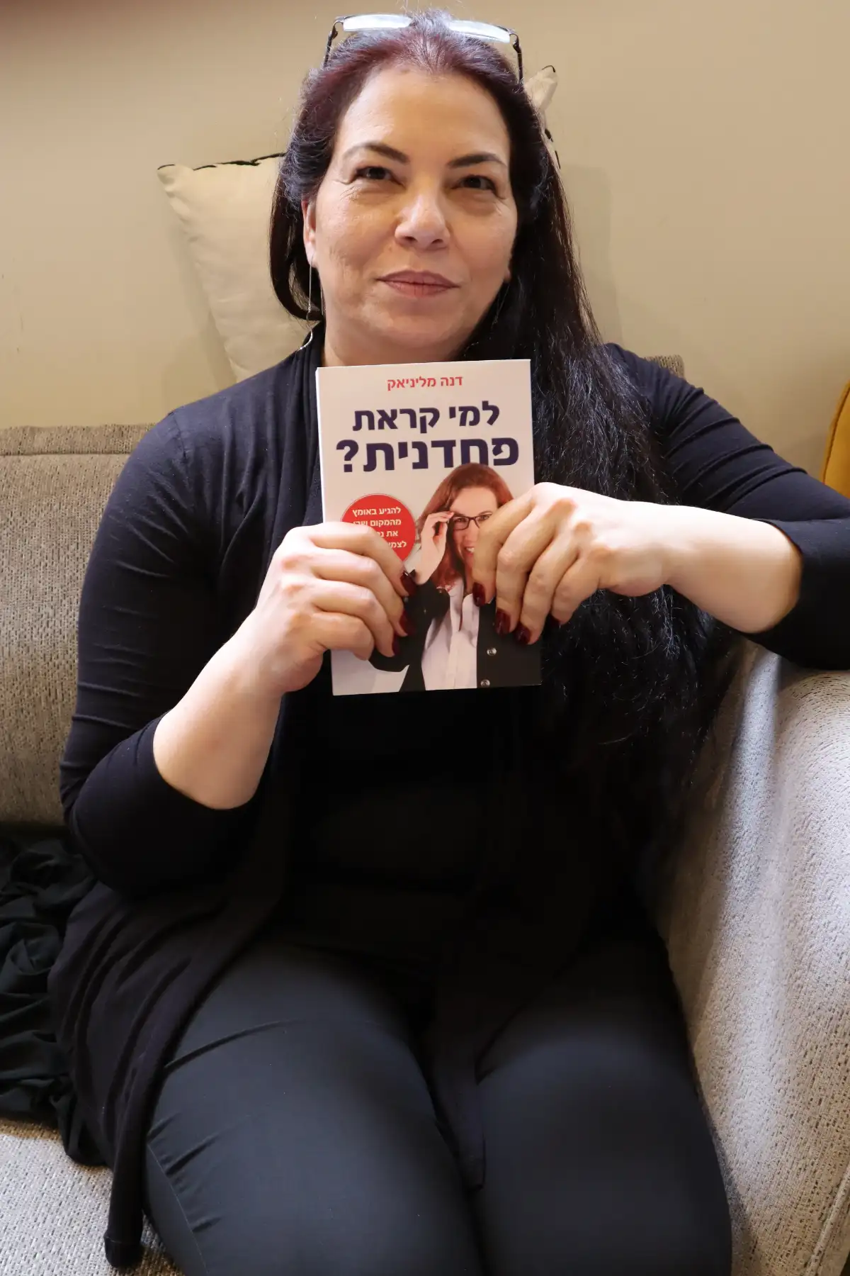 קוראת מחזיקה את הספר למי קראת פחדנית