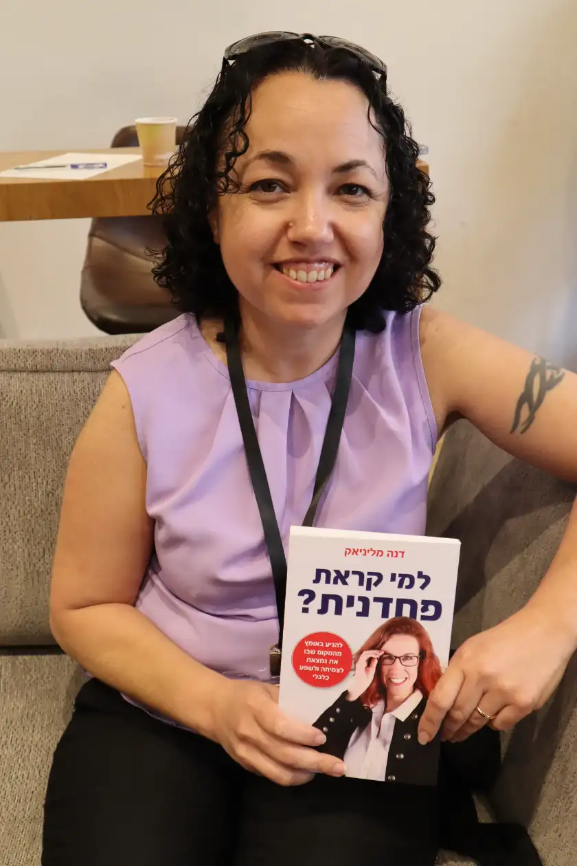 קוראת מחזיקה את הספר למי קראת פחדנית