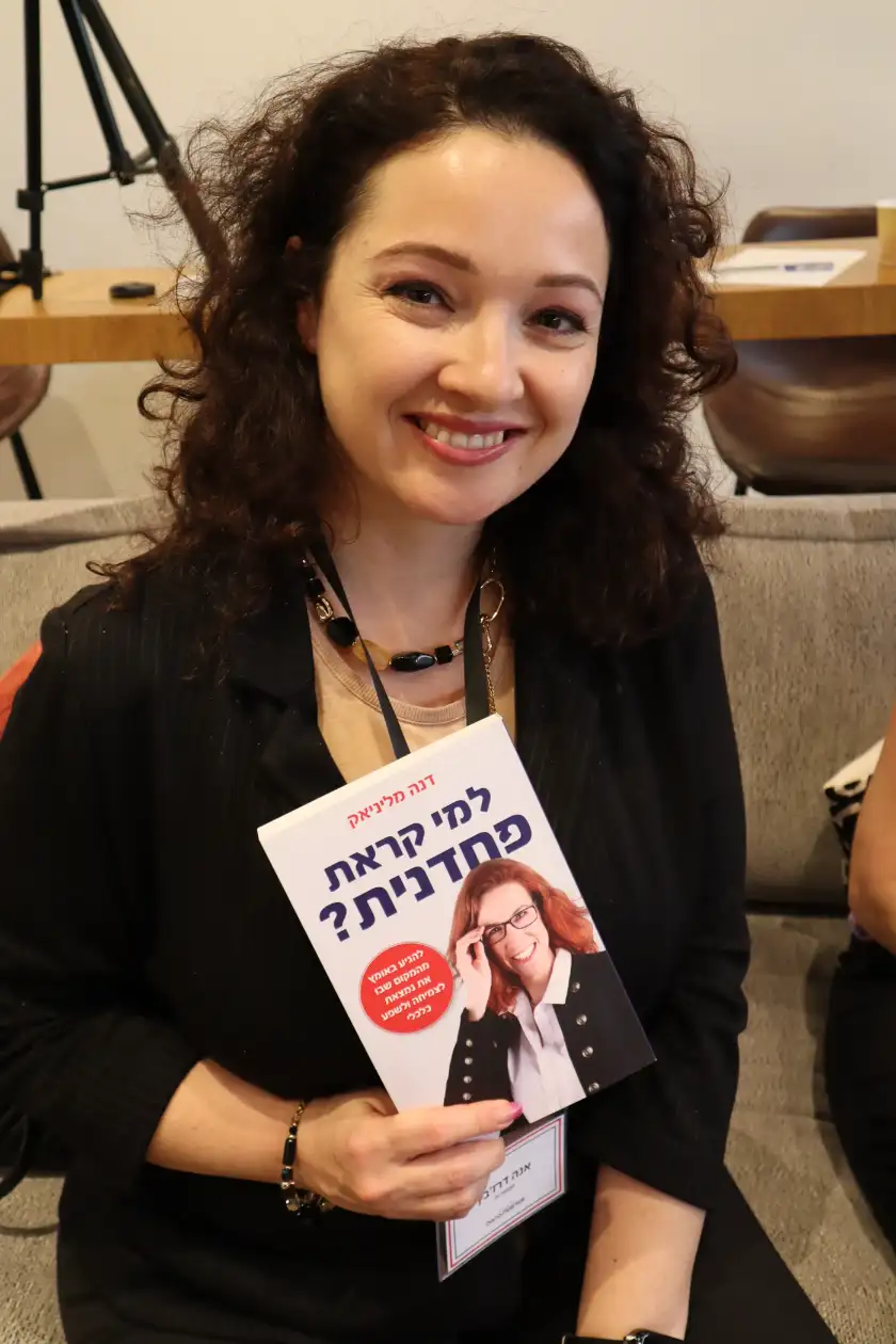 קוראת מחזיקה את הספר למי קראת פחדנית