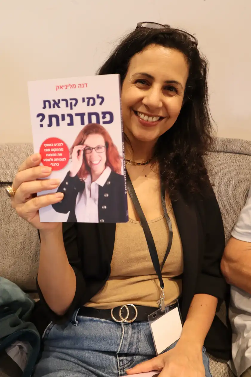 קוראת מחזיקה את הספר למי קראת פחדנית
